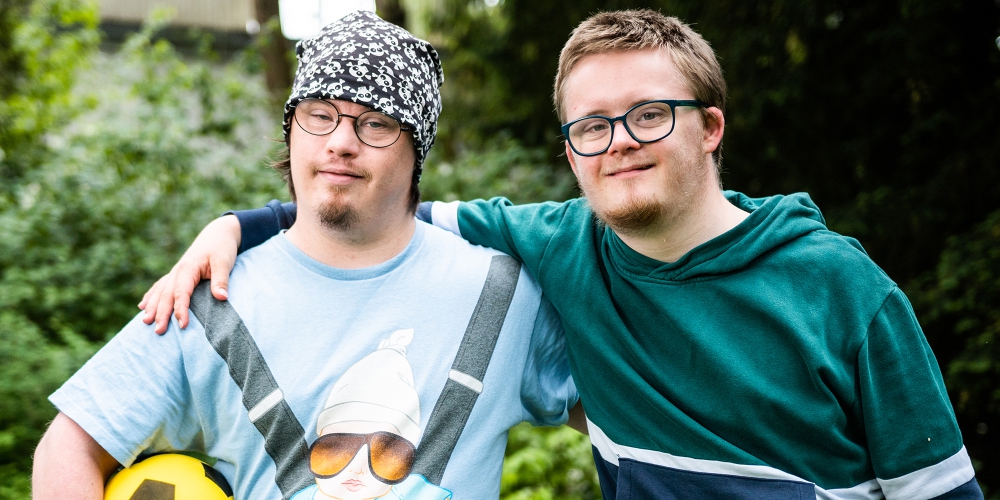 Zwei junge Männer mit Down-Syndrom mit Fußball