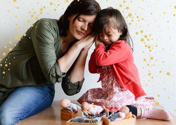 Mädchen und Logopädin spielen bei der Behandlung mit Puppen