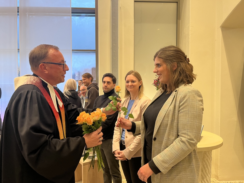 Uwe Mletzko übergibt Rose an leitende Mitarbeiterin