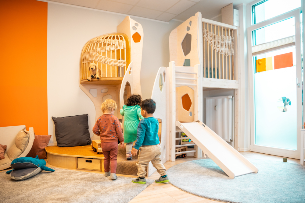 Kinder spielen drinnen an einem Klettergerüst mit Rutsche