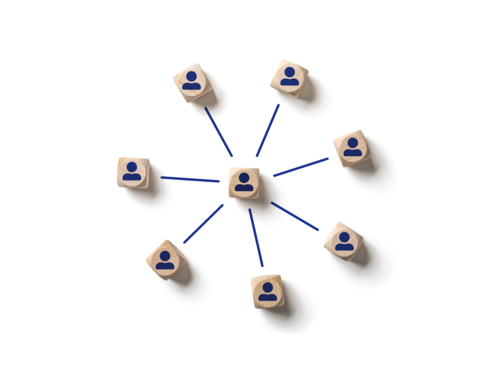 Würfel mit dem Symbol einer Person sind in einem Kreis angeordnet und miteinander durch Striche verbunden.