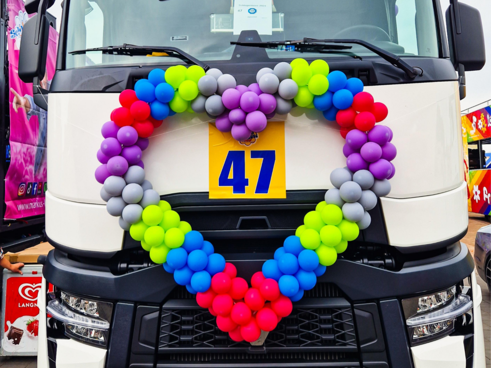 Der Truck ist von vorne zu sehen mit einem großen Herz aus Luftballons in ESA-Farben vorne drauf.
