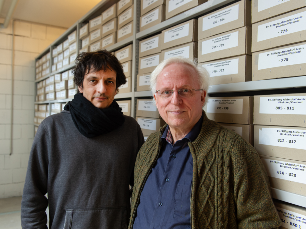 Die beiden Archivare gucken in die Kamera.