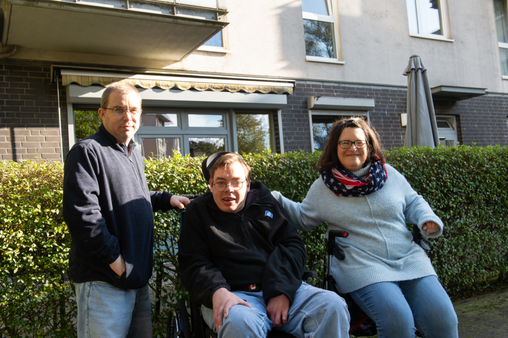Gruppenbild der Beirät*innen, sie stehen und sitzen draußen vor einem Haus.