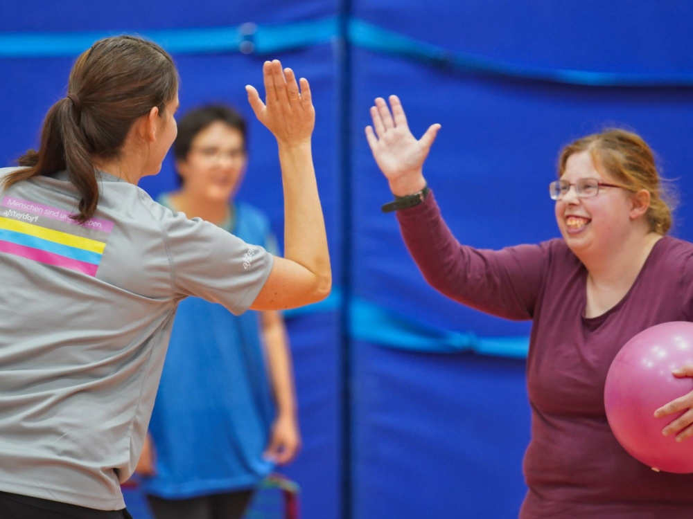 Zwei Personen geben sich einen High-Five beim Sport