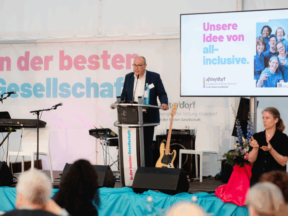 Der Diakonie-Präsident Rüdiger Schuch hält einen Impuls-Vortrag. Er steht auf einer Bühne und spricht vor Publikum.