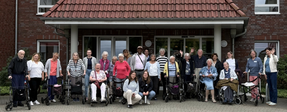 Viele insbesondere ältere Menschen stehen vor dem Eingang eines Hauses.