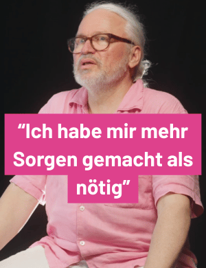 Thumbnail, Mann mit langen weißen Haaren und pinkem Shirt im Interview